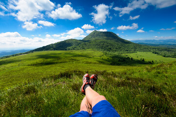 Puy de Dome mountain and hikers legs, Auvergne