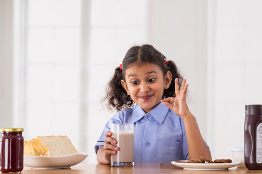 A Girl in school uniform drinking fresh delicious chocolate milkshake