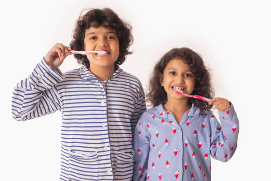 Portrait of Sibling brushing teeth together with toothbrush