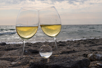 Romantic glass of white wine, on the sea beach. Wine tasting and relaxation at the resort
