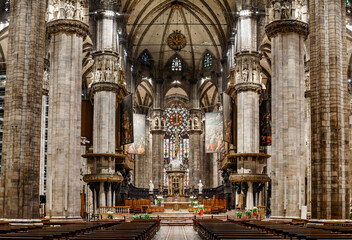 Fototapeta na wymiar Altar with statues and a huge stained glass window in the Duomo. Italy, Milan