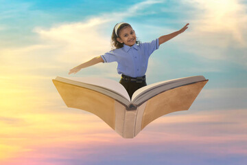 A girl in school uniform flying on book in the sky with open arms