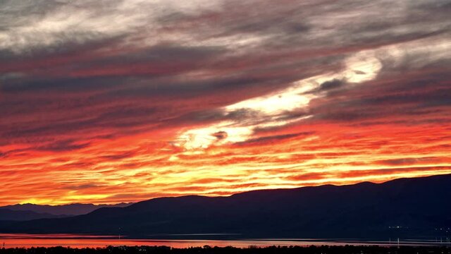 Timelapse of fiery sunset over Utah Lake zoomed across the valley as the wave of color fades.