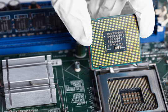 Hand With White Glove Holding CPU Or Microprocessor And Electronic Circuit Board.