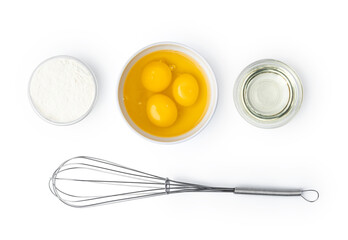 Metal whisk and eggs for cooking isolated on white
