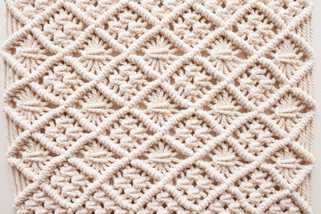 Handmade macrame. Macrame braiding and cotton threads.  Female hobby.  ECO friendly modern knitting DIY natural decoration concept in the interior.  100% cotton wall decoration.