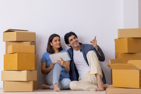 Indian Middle Age Couple Planning Together For New Ideas On The Decoration Of New Room