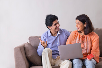 Fototapeta premium Indian middle age couple shopping online through laptop using credit card