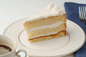 Piece of white biscuit cake on plate