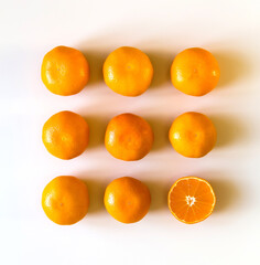 Mandarin or tangerine citrus fruit on white background. Whole and cut fruits. Top view.