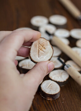 handmade carving ansuz rune closeup, wooden blanks and tools for runes carving