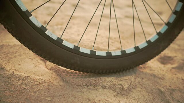 Bicycle Wheel on Golden Sand. Spokes and Rubber Tire Middle Plans. Concept of Cycling in Difficult Places. Cycling and Cycling Concept, Adventure and Travel Concept