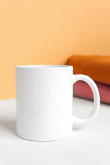 White cup close-up on a solid background, front view. Mockup, template for inserting text and ads, copy space.