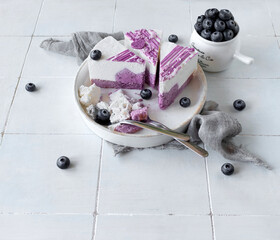 Blueberry mousse cake with fresh berries on a light background. Top view