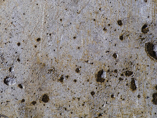 Textured concrete background with many potholes, scratches, irregularities, scuffs with colored traces. Horizontal