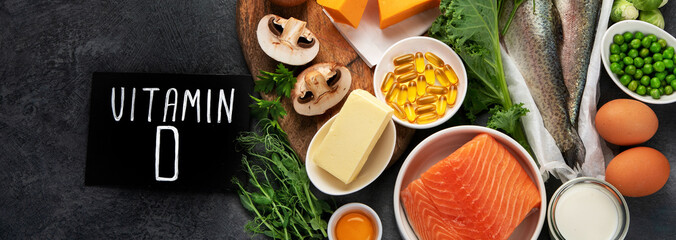 Foods high in vitamin D on dark background.
