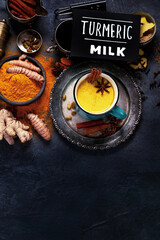 Obraz na płótnie Canvas Healthy turmeric golden milk on dark background.