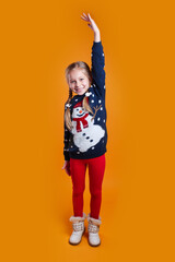 Funny little girl in a Christmas sweater is having fun. Happy New Year and Christmas