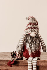 Scandinavian traditional gnomes, tomte, nisse, sitting on wooden table or shelf , copy  space
