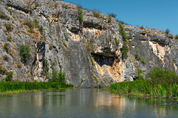 high cliffs and trees along the banks of a beautiful and calm river