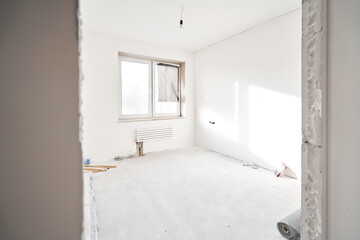 Fototapeta premium connection heating pipes to white Radiator in a new apartment under construction. Work As A Plumber, mounting water heating radiator on the white wall indoors