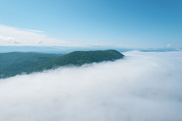 Flying through the clouds above mountain tops. High peaks wonderful morning sunrise natural Landscape