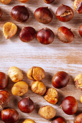 Roasted chestnuts, shot from above on a rustic wooden background with a place for text, autumn banner design