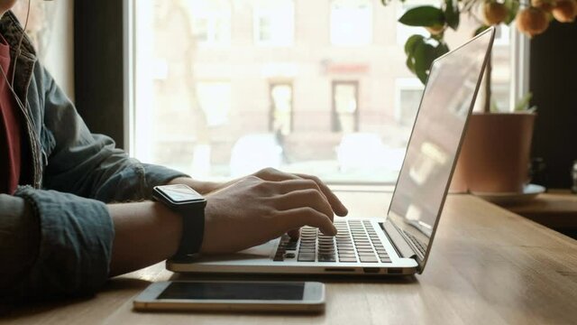 Man's hands typing on laptop keyboard