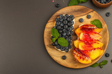Tasty toast bread with cream cheese and ripe fruits
