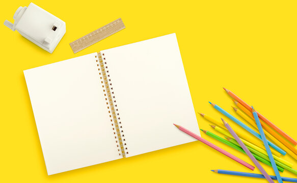 Blank notebook with colored pencils, ruler and sharpener on a yellow background. Flat lay. Copy space.