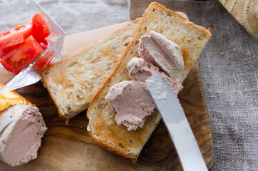 焼いたパンにレバーペーストを塗る朝食