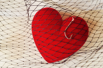 Heart with fish hook in fishing net - Love and freedom concept - obrazy, fototapety, plakaty