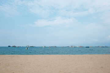 boats in Pattaya sea, beach, and urban city with blue sky for travel background. Chonburi, Thailand.