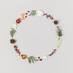 Round natural frame or wreath made of christmas ornaments, greens and pine cones.