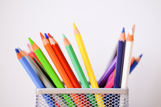 Colored pencils in a glass on the desktop. Back to school. Organizer for pencils. Organization of a table for children