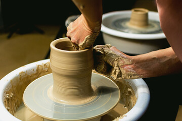 Master class on modeling of clay on a potter's wheel In the pottery workshop.