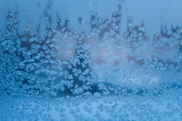 Ice flowers. Window frost. Winter time background. Frozen icy texture