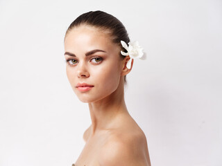 Fototapeta premium attractive woman naked shoulders white flower in hair makeup clean skin