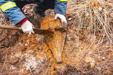 Man hands keep old iron fragments, clean them from dirt, clay, land and rust, after searching and producing scrap metal in forest.