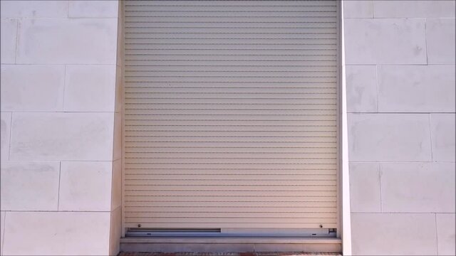 Outside view of electric security shutters on sliding patio doors opening 