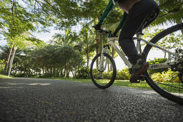 Woman riding bike at park on sunny day