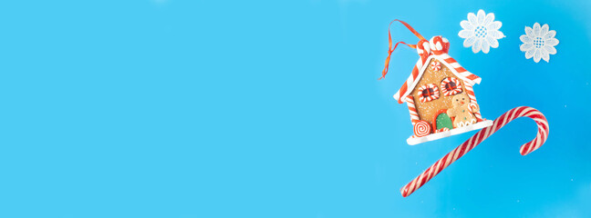 Gingerbread house, lollipop, candy on a blue background. Banner. Space for copying.. Banner.