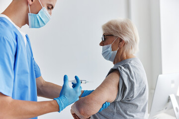 elderly woman next to the doctor arm injection vaccine passport immunization safety