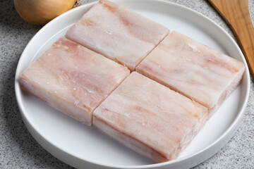Dish with pieces of frozen Pollock fish fillet as an ingredient for cooking close up   