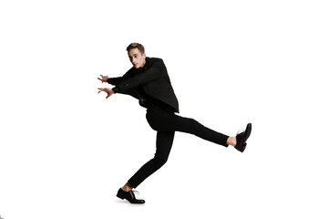 Fototapeta na wymiar Young man in black business suit dancing isolated on white background. Art, motion, action, flexibility, inspiration concept.
