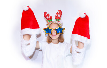 A young girl, a teenager, in deer horns and star glasses with hats of Santa Claus or Santa Claus on a white background.