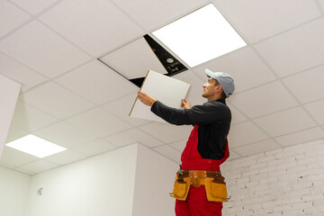 Ceiling installation with expert technicians In the room that is in the construction process. © Angelov