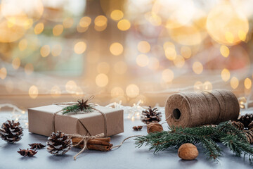 Christmas zero waste packaging gift boxes with pine cones, wooden eco decor and Christmas lights