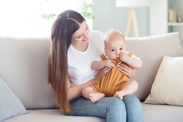 Photo of positive nice glad mother lady embrace cute son sit comfy couch wear white t-shirt home indoors