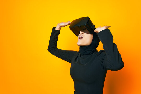 pretty woman in black hijab VR glasses emotions isolated background